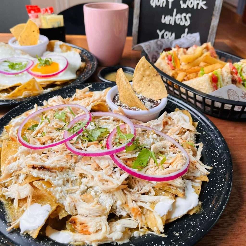 Platillos enchilada de pollo, huevos y club sadwich con vaso de cafe